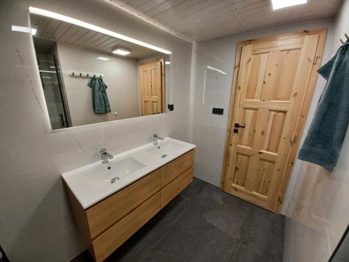 a bathroom with a sink and a mirror and a door at Chata Vedle Jedle in Dolní Morava