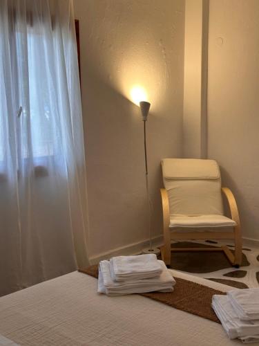 a room with a bed and a chair and a window at Villa Ethel Vourvourou in Vourvourou