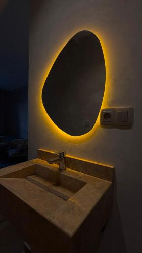 a bathroom with a sink and a mirror at HoneyPath Ocean Retreat in Tamraght Ouzdar