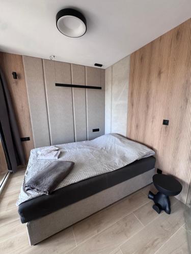 a bedroom with a bed and a black table at Diuna Apartamenty in Rowy