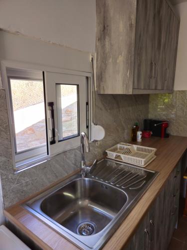 a kitchen with a stainless steel sink and a window at Casa Verde in Lukovë