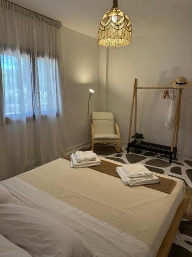 a bedroom with a bed and a chair and a chandelier at Villa Ethel Vourvourou in Vourvourou