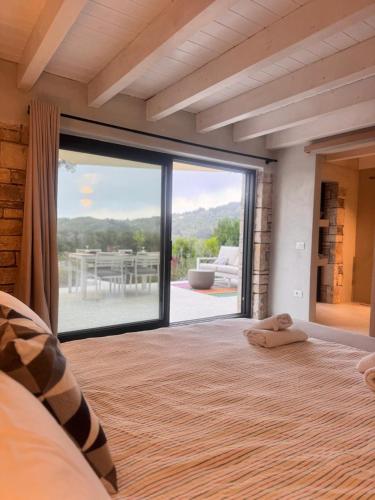 a bedroom with a large sliding glass door with a patio at Lucié in Argyrátika