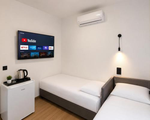 two beds in a room with a tv on the wall at ECO HOUSE in Szypliszki