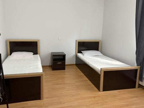 two beds in a room with two tables and a bedskirtspectspectspectspects at redHome in Gabala