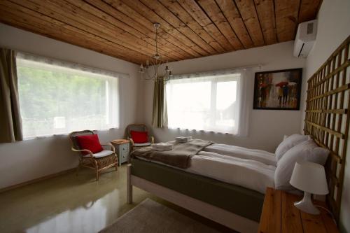 a bedroom with a large bed and two red chairs at Green Escape-Entire House in Moldoveneşti