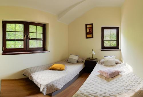 two beds in a room with two windows at Zaciszna Przystań Dębina in Debina