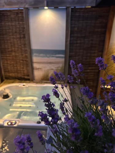 a spa tub with a view of the beach at Zeeuws Ontspannen - Privé Wellness & Suites in Middelburg