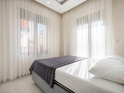 a bedroom with a bed and two windows at The Orange Cactus in Antalya