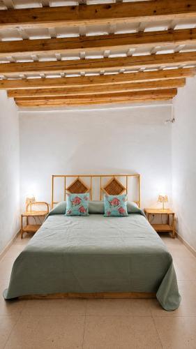 ein Schlafzimmer mit einem großen grünen Bett und zwei Tischen in der Unterkunft Arkea in Trapani