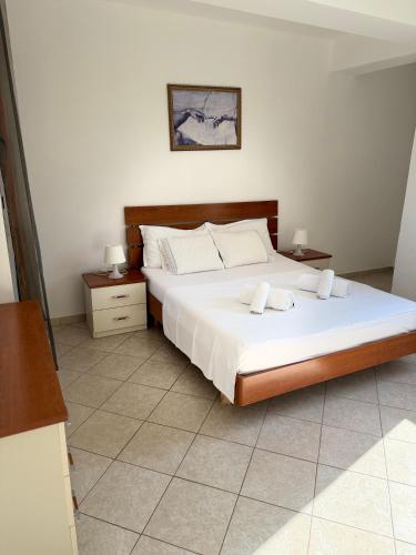a bedroom with a large bed and two night stands at Saranda Port View Apartments in Sarandë