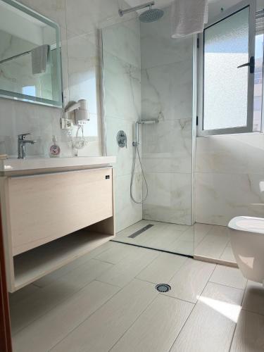 a bathroom with a shower and a sink and a toilet at Saranda Port View Apartments in Sarandë