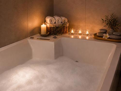 a bath tub with a candle and a basket of towels at Tourist Farm Ranč Velka in Spodnja Velka