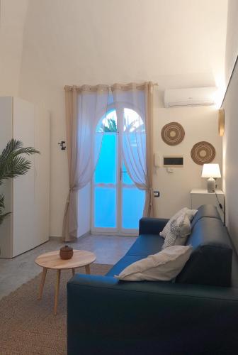 a living room with a blue couch and a window at Casa Mare Blu in Imperia