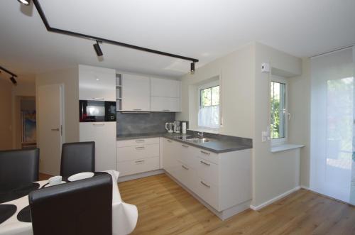 a kitchen with white cabinets and a black counter top at Ferienwohnung Dorada in Neukirch