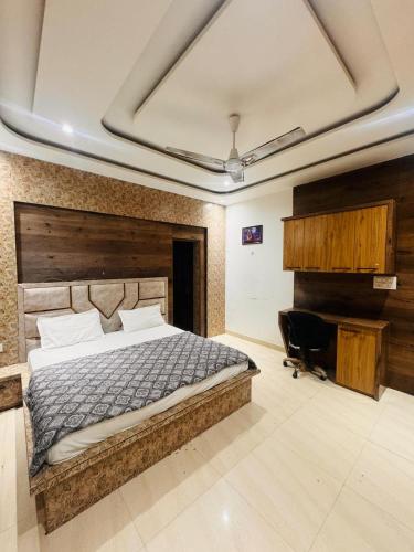 a bedroom with a large bed and a desk at shyam hotel rexa in Vrindāvan