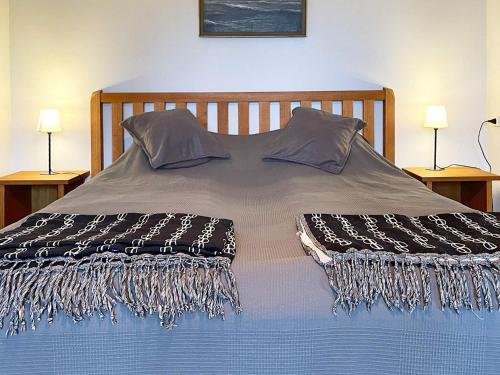 a bed with a blanket on it with two lamps at 8 person holiday home in Beddingestrand-By Traum in Beddinge Strand