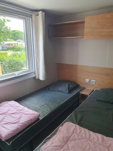 a small room with two beds and a window at HerGine in Pérols