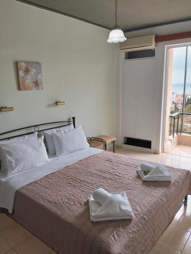 a bedroom with a large bed with two towels on it at Hotel Tainaro in Loutra Edipsou