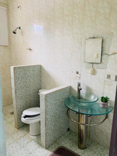 a bathroom with a toilet and a glass sink at Casa céntrica en Paraíso Amplia y cómoda in Paraíso