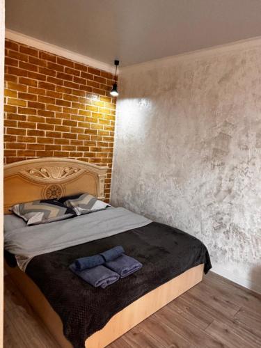 a bedroom with a bed with a brick wall at Жк сокол in Kokshetau