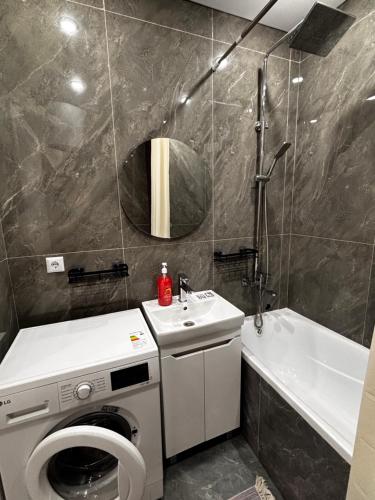 a bathroom with a washing machine and a sink at Жк сокол in Kokshetau