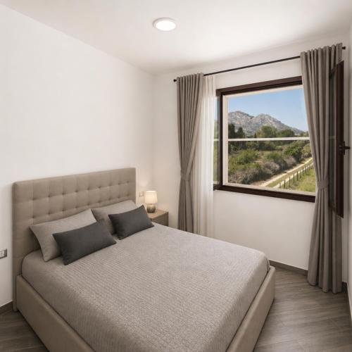 a bedroom with a bed and a large window at Sa lampana in Orosei