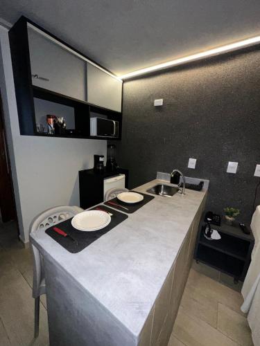 a kitchen with a sink and a counter with plates on it at Blue Sunset Flats Beira Mar - Apt 322 in João Pessoa