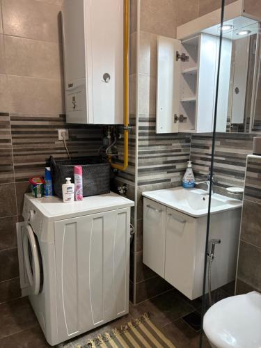a bathroom with a washing machine and a sink at Apartment Centar Sarajevo in Sarajevo