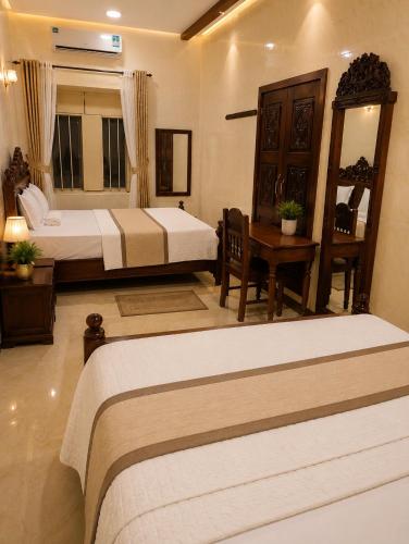 a hotel room with two beds and a desk and a room at Zanzibar stone town house in Zanzibar City