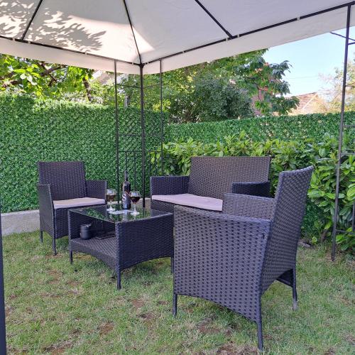 an outdoor table and chairs with an umbrella at Ljubičica deluxe 2 - Novo - Privatno dvorište - Parking in Vrnjačka Banja