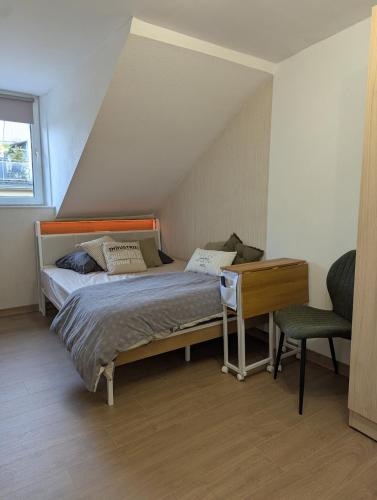 a bedroom with a bed and a desk and a chair at L'industriel in Sarreguemines