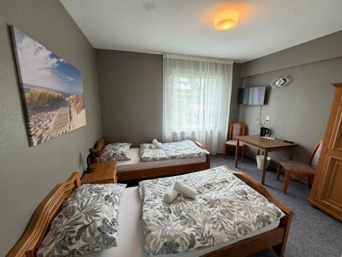 a hotel room with two beds and a table at Wald Hotel in Kirschweiler