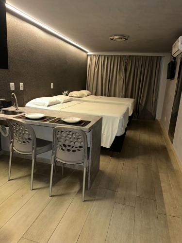 a bedroom with a bed and a table and chairs at Blue Sunset Flats Beira Mar - Apt 322 in João Pessoa