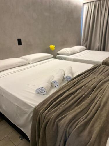 two beds with white sheets and towels on them at Blue Sunset Flats Beira Mar - Apt 217 in João Pessoa