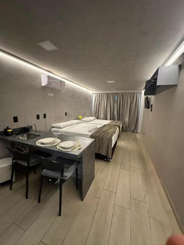 a hotel room with a bed and a table with plates on it at Blue Sunset Flats Beira Mar - Apt 217 in João Pessoa