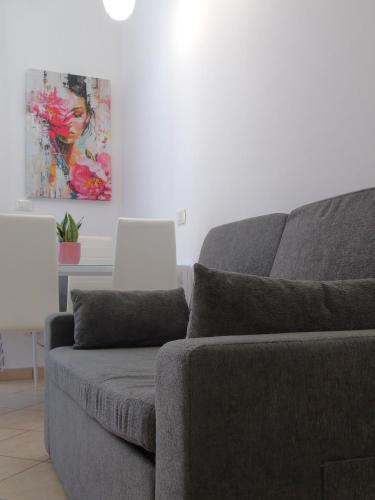 a gray couch in a living room with a painting at DOS Gardenias B&B in Pozzuoli