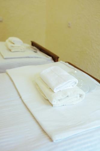 two white towels sitting on top of a bed at Abelyans Fam Hotel in Alaverdi