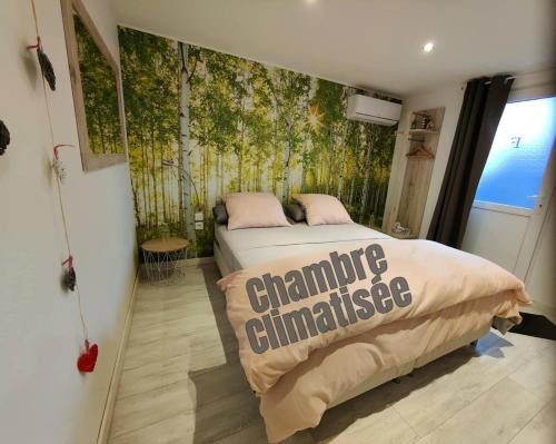 ein Schlafzimmer mit einem Bett und einer grünen Wand in der Unterkunft Chez Stef in Marckolsheim