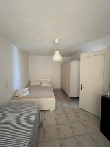 a small bedroom with two beds and a closet at Avli Cozy Home in Karditsomagoúla