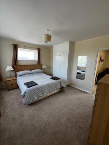 a bedroom with a large bed and a window at Spacious 2 bedroom apartment near Wembley stadium with free parking in London