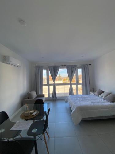 a bedroom with a bed and a table and a dining room at Monoambiente Cipolletti in Cipolletti
