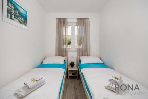 two beds in a small room with white walls at Rona Apartments Zlatko in Šimuni