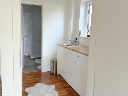 a white bathroom with a sink and a mirror at Horizon Apartments in Memmingen