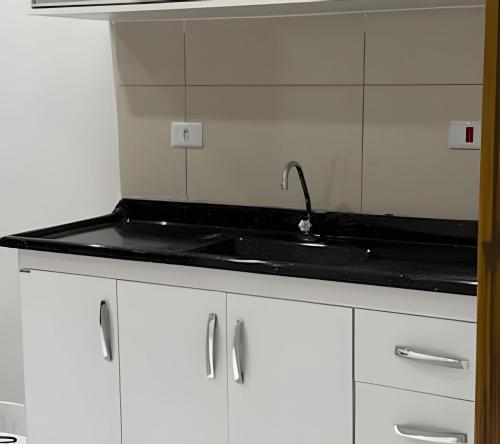 a kitchen with a sink and a mirror at Lady Estúdio - Hotel + café em Extrema MG in Extrema