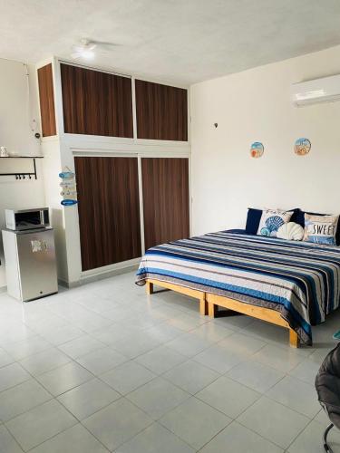 a bedroom with a bed and a refrigerator in it at Paraiso Suite Centrico con entrada independiente in Paraíso