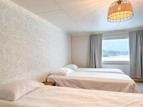 a bedroom with two beds and a window at Maalaistalo maatilamiljöössä in Haapavesi