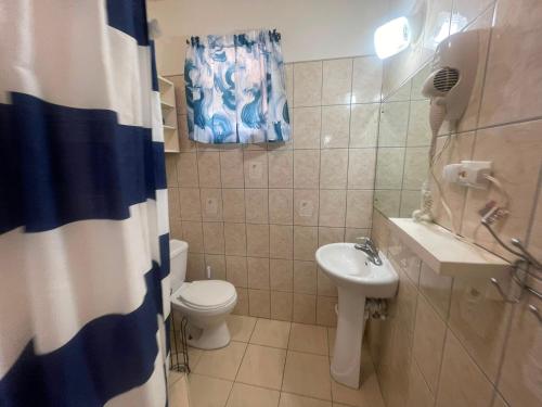 a bathroom with a toilet and a sink at Cozy Suite, Wifi, Ac in Bedroom & 1 Minute Walk to West Coast Beach! in Saint James