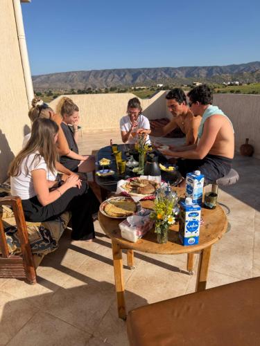 a group of people sitting around a table at Gaia guest house in Taghazout