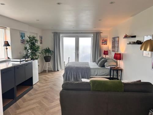 a bedroom with a bed and a large window at Follies Garden Studio in Dungarvan